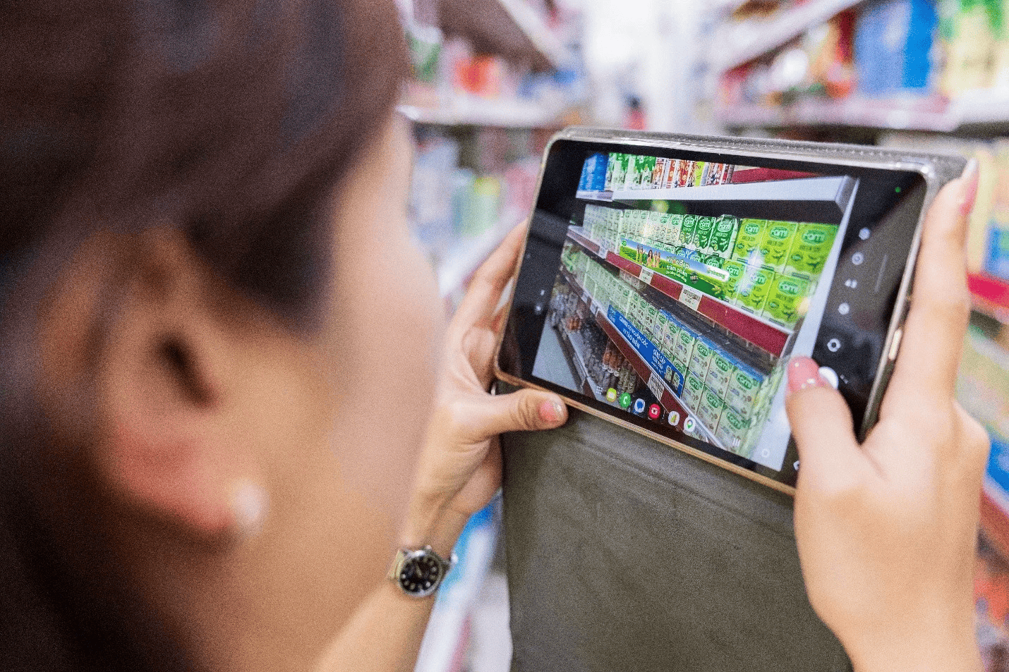 Staff is taking pictures of products on the shelf to check on the platform. [Source: Vinasoy]
